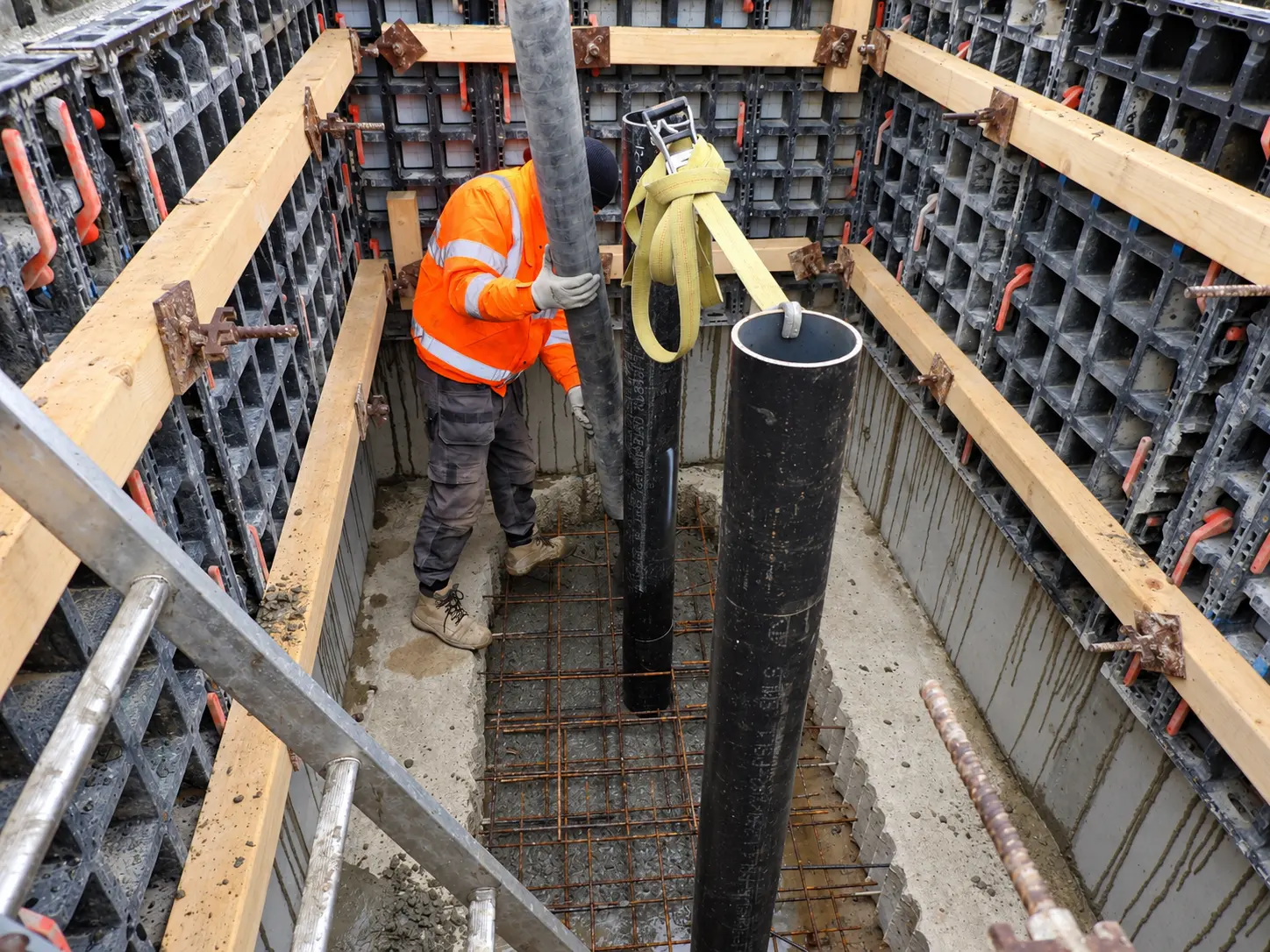 Operative installing pipework within reinforced concrete formwork at RAF Mildenhall