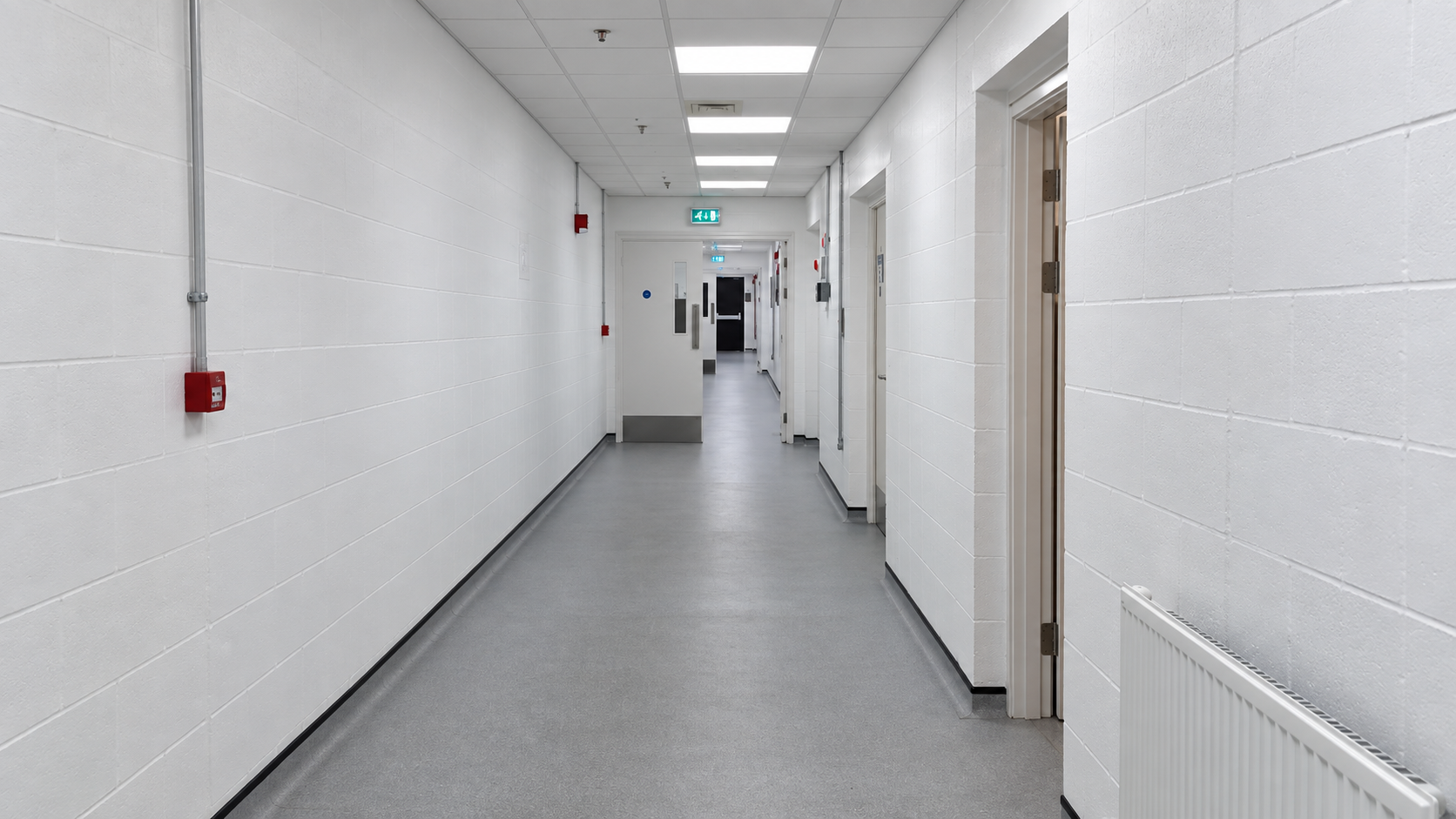 Refurbished white-painted corridor with new doors, lighting and flooring at RAF Mildenhall