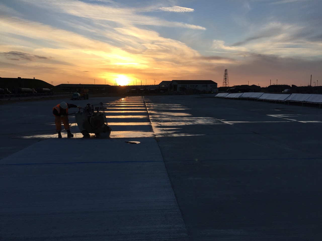 Operative power-floating the new concrete hardstanding at sunset on the RAF Lakenheath refurbishment