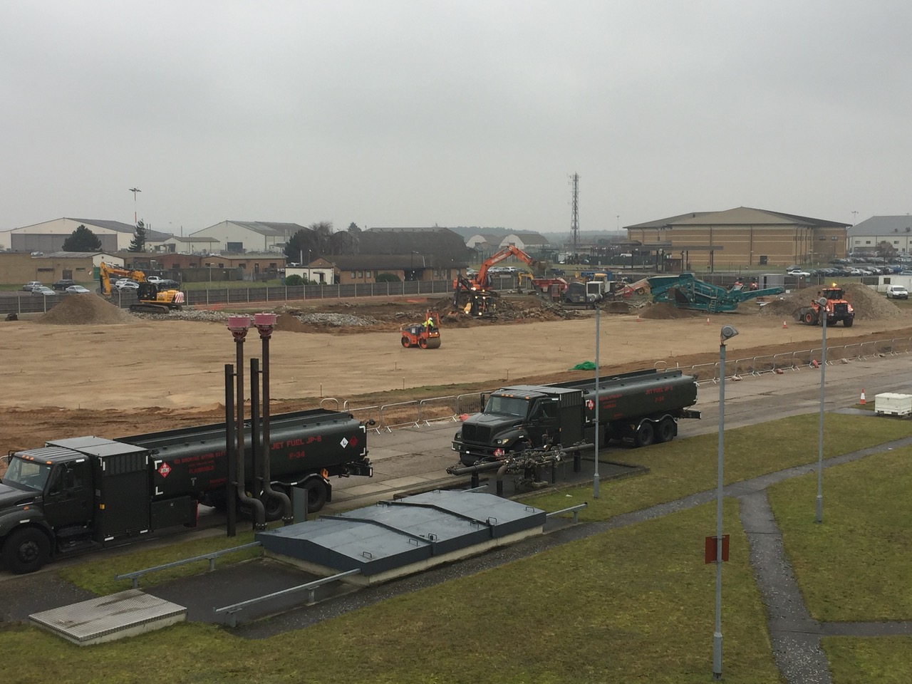 Military fuel tankers and earthworks plant working on the refurbished fuel-truck parking area at RAF Lakenheath